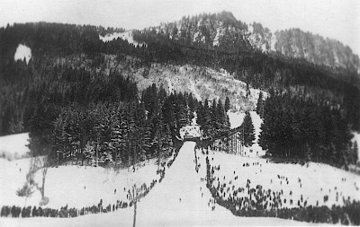 1925 wurden die Deutschen und Österreichischen Meisterschaften in Kitzbühel ausgetragen. Man beachte die Tribüne (Grub Schanze) und den Baum, der mitten im Auslauf stand.